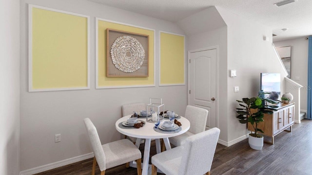 dining room with dark hardwood / wood-style floors and a textured ceiling