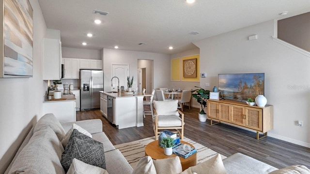 living room with dark hardwood / wood-style flooring and sink