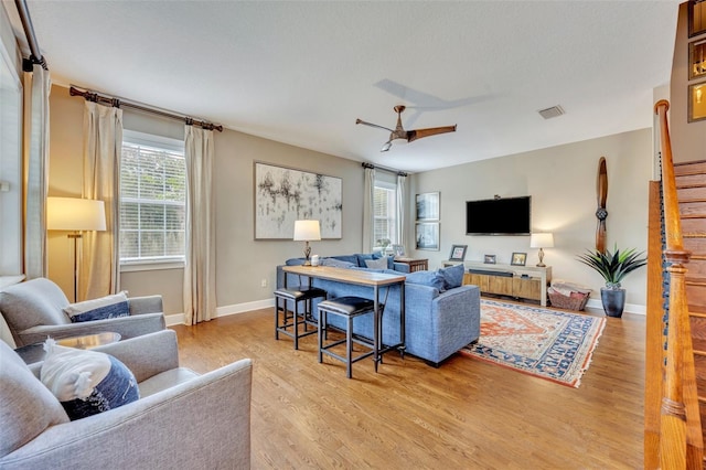 living room featuring light hardwood / wood-style flooring and ceiling fan