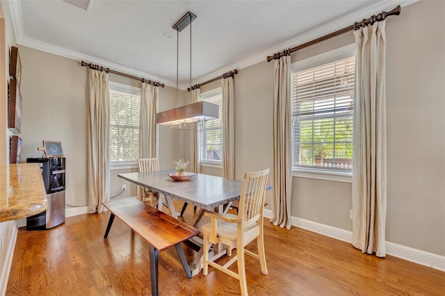 dining room with crown molding and light hardwood / wood-style floors