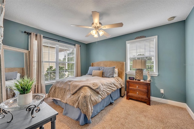 carpeted bedroom with ceiling fan and a textured ceiling