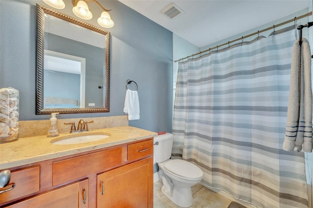 bathroom with tile patterned flooring, vanity, and toilet