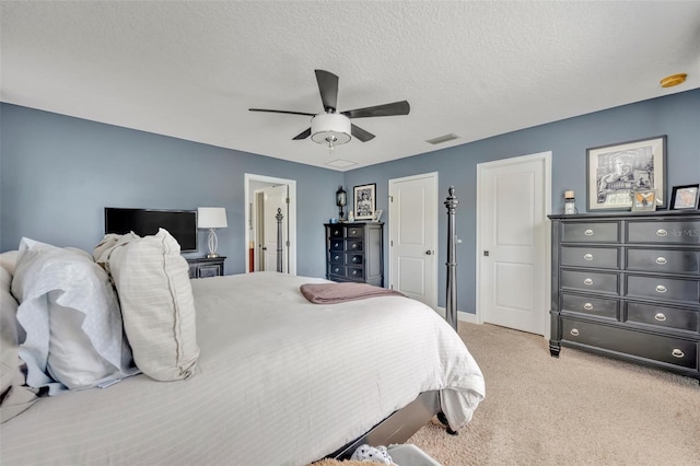 carpeted bedroom with ceiling fan and a textured ceiling