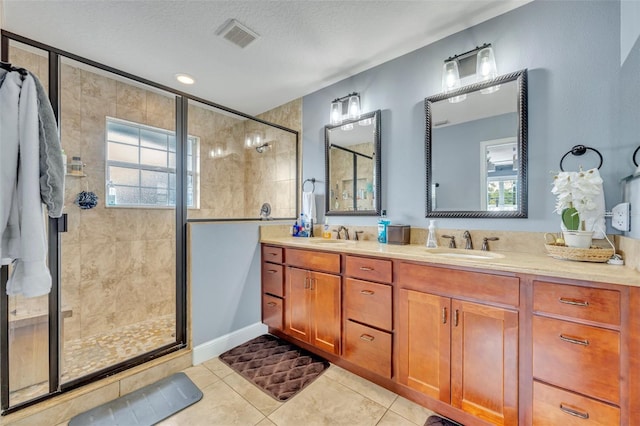 bathroom featuring tile patterned floors, a shower with shower door, a textured ceiling, and a wealth of natural light