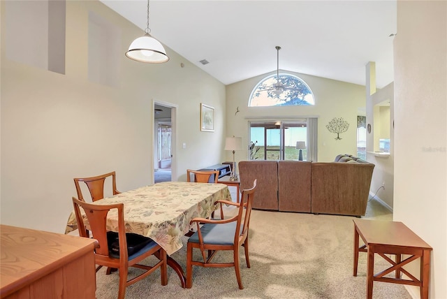 carpeted dining area with high vaulted ceiling