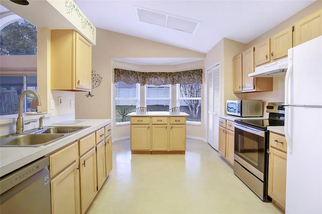 kitchen with vaulted ceiling, appliances with stainless steel finishes, light brown cabinetry, and sink