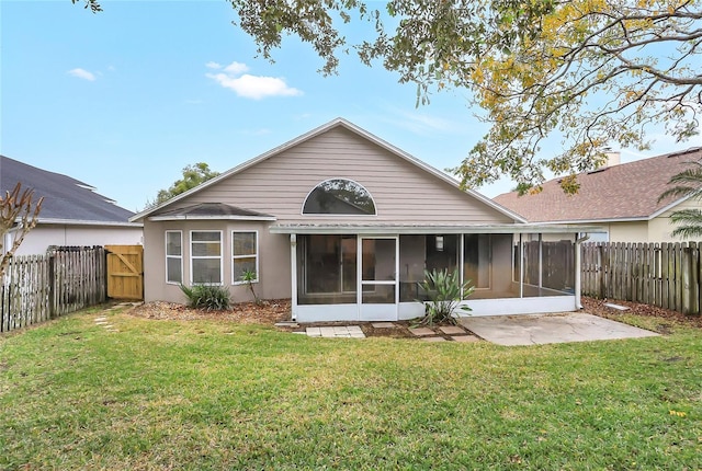 rear view of house featuring a sunroom and a lawn