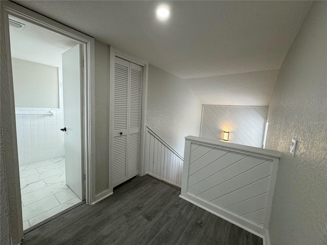 hall with vaulted ceiling and dark hardwood / wood-style floors