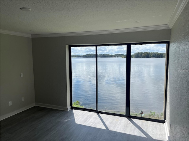 spare room with a textured ceiling, a water view, crown molding, and hardwood / wood-style flooring