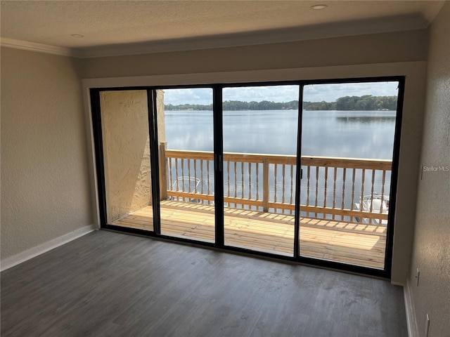 unfurnished room with a textured ceiling, ornamental molding, dark hardwood / wood-style floors, and a water view