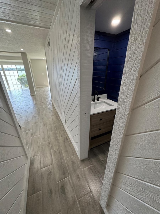 corridor with sink and wooden walls