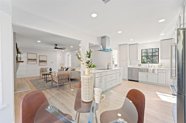 dining room featuring ceiling fan, sink, and light hardwood / wood-style floors