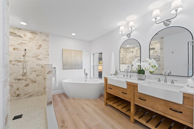 bathroom with plus walk in shower, vanity, and hardwood / wood-style flooring