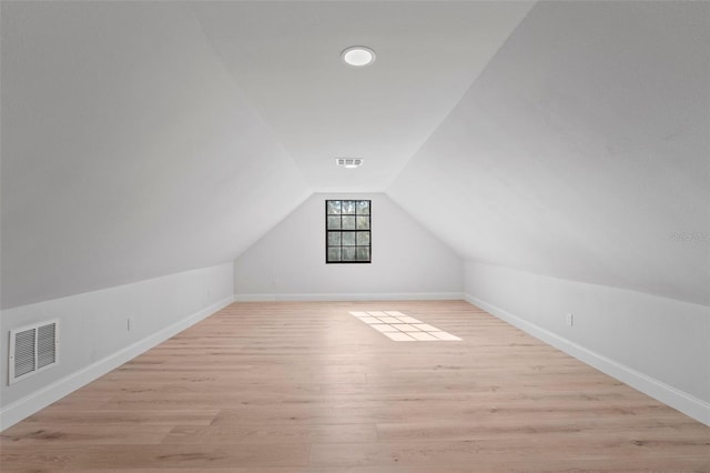 additional living space featuring light hardwood / wood-style flooring and lofted ceiling