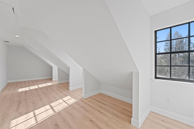 bonus room with light hardwood / wood-style flooring and vaulted ceiling