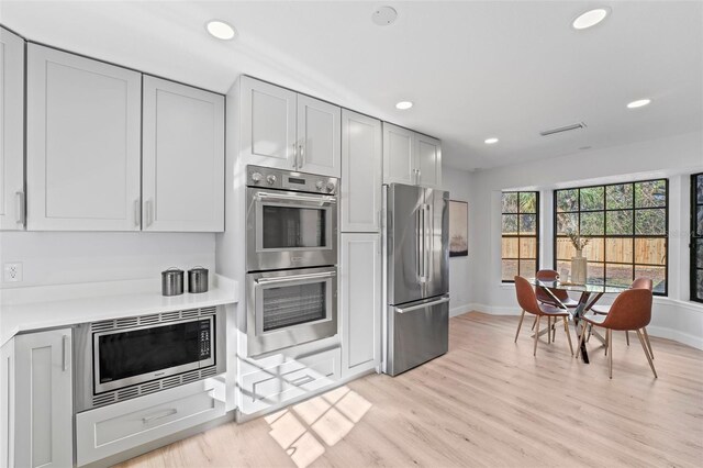 417 Main Trl, Ormond Beach, FL 32174 - kitchen with stainless steel appliances, baseboards, light wood-style flooring, recessed lighting, and light countertops