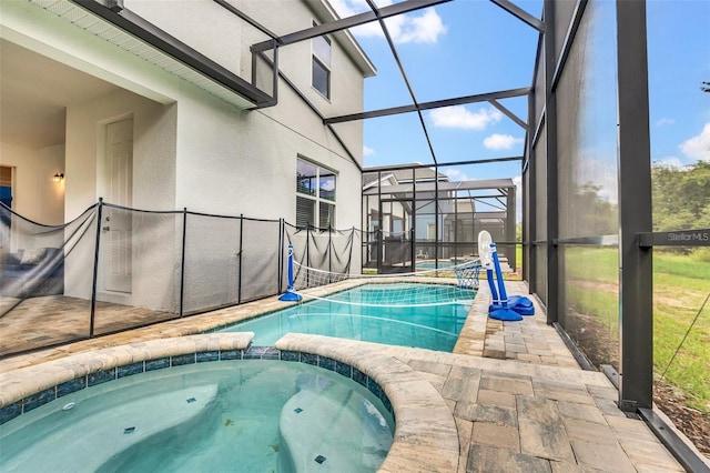 view of swimming pool featuring glass enclosure, an in ground hot tub, and a patio