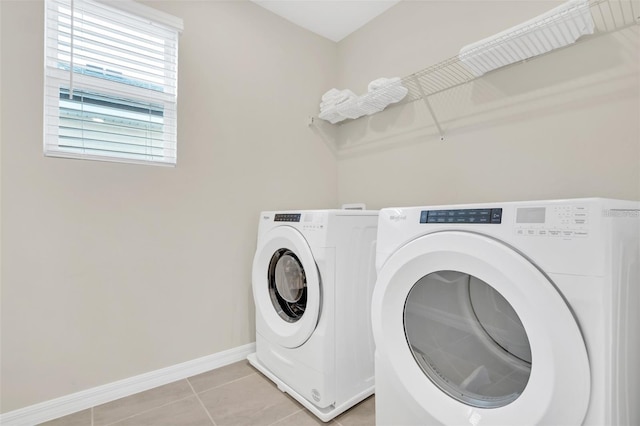 washroom with washer and clothes dryer and light tile patterned floors