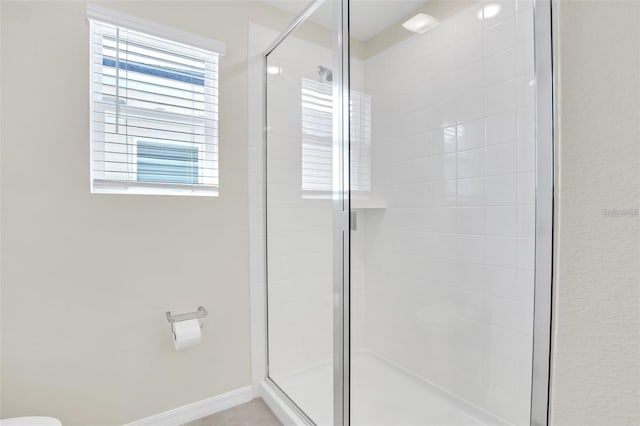 bathroom featuring toilet and a shower with door