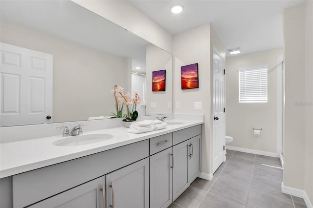 bathroom featuring tile patterned flooring, vanity, toilet, and a shower with door