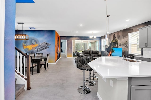 kitchen featuring a chandelier, decorative light fixtures, gray cabinetry, and sink