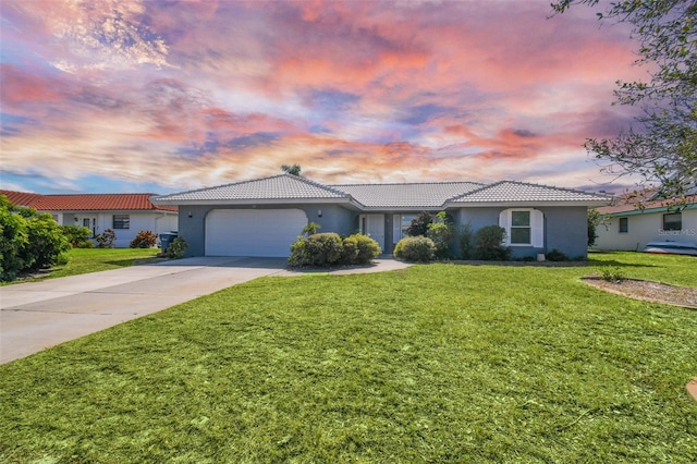 ranch-style house featuring a garage and a yard