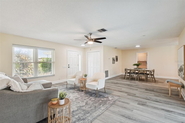 living room featuring light hardwood / wood-style floors and ceiling fan