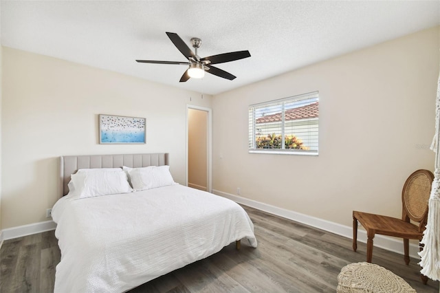 bedroom featuring a textured ceiling, dark hardwood / wood-style floors, and ceiling fan