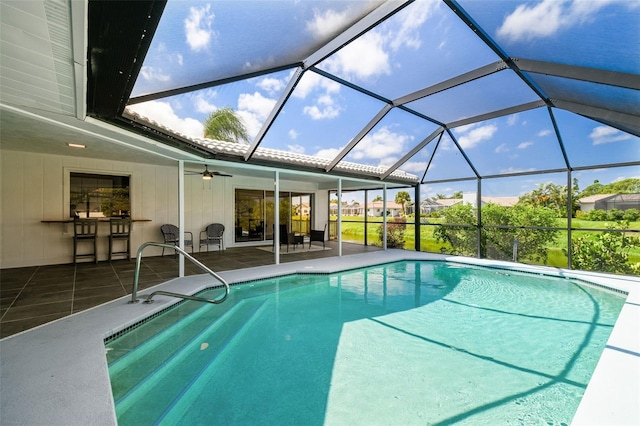 view of swimming pool featuring a lanai, a patio area, and ceiling fan