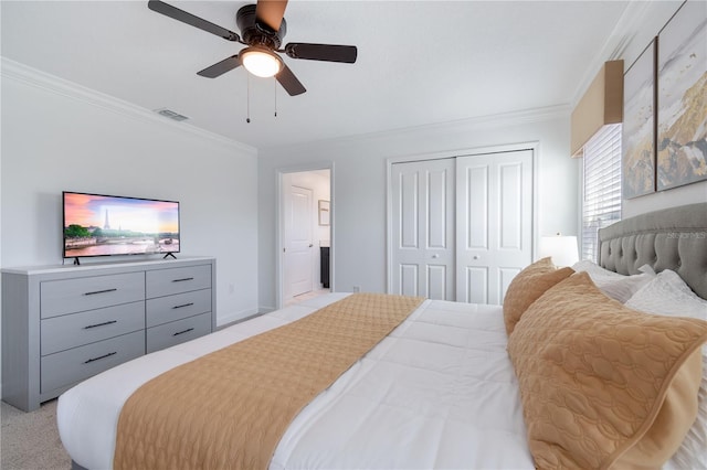 carpeted bedroom featuring ceiling fan, ornamental molding, and a closet