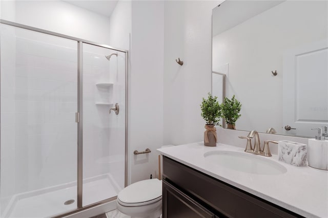 bathroom featuring a shower with door, vanity, and toilet