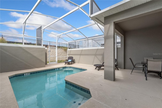 view of swimming pool with glass enclosure and a patio area