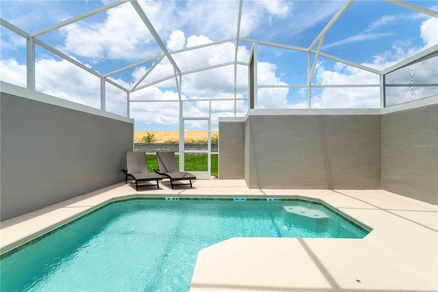 view of pool featuring glass enclosure and a patio area