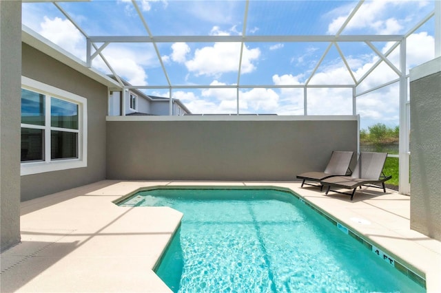 view of pool featuring glass enclosure and a patio