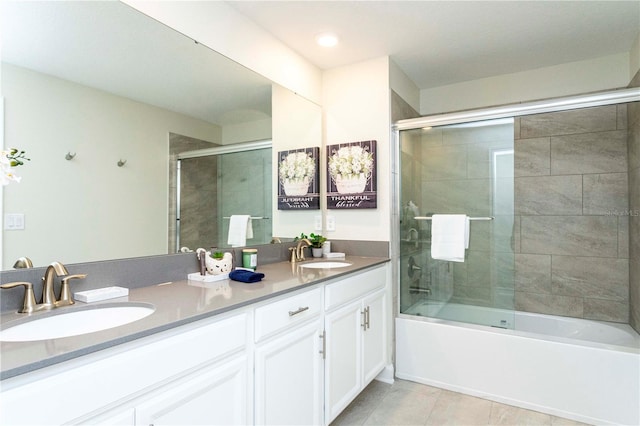 bathroom with tile patterned floors, vanity, and bath / shower combo with glass door