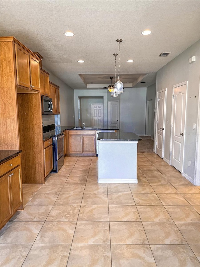 kitchen featuring pendant lighting, light tile patterned flooring, kitchen peninsula, and appliances with stainless steel finishes