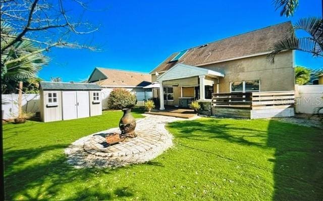 rear view of house with a shed and a yard