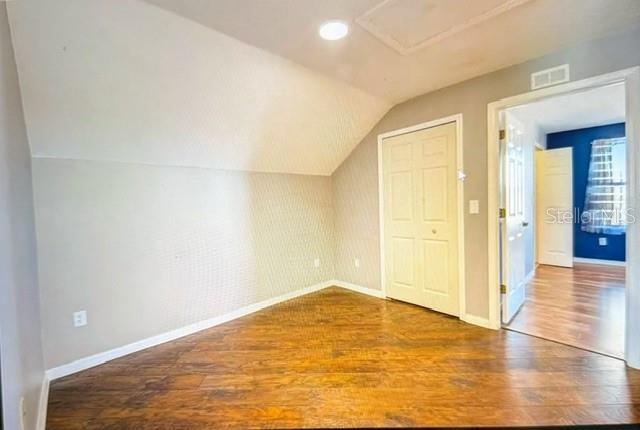 bonus room featuring vaulted ceiling and hardwood / wood-style flooring