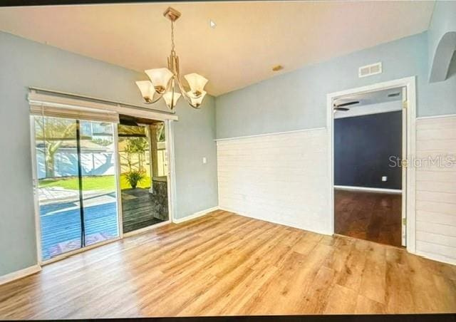 unfurnished room featuring hardwood / wood-style floors and a notable chandelier