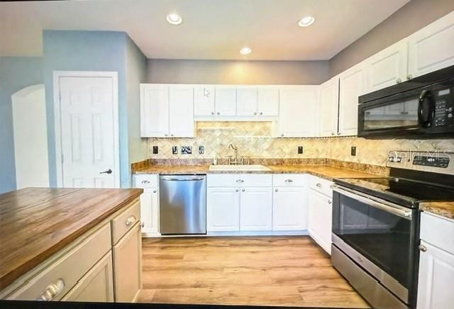 kitchen with white cabinets, appliances with stainless steel finishes, sink, and wood counters