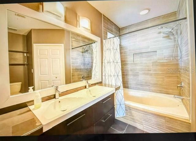 full bathroom with tile patterned floors, toilet, vanity, and shower / bathtub combination with curtain