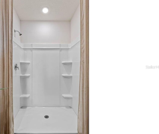 bathroom featuring a shower and a textured ceiling