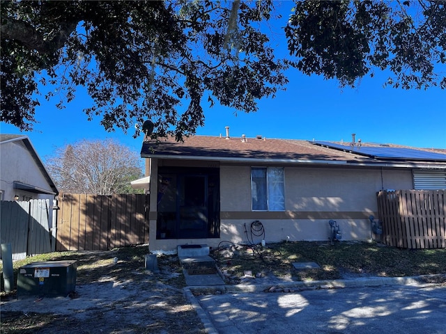 view of front of house featuring roof with shingles and fence