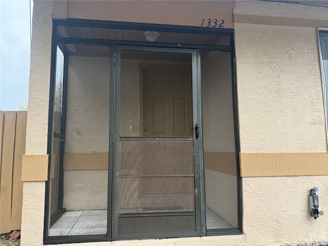 doorway to property featuring stucco siding