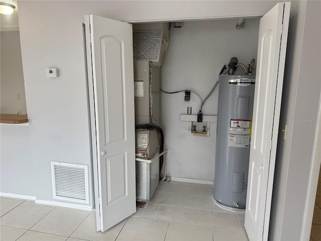 utility room featuring water heater and visible vents