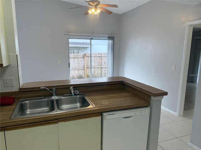 kitchen featuring baseboards, light tile patterned floors, white dishwasher, a ceiling fan, and a sink