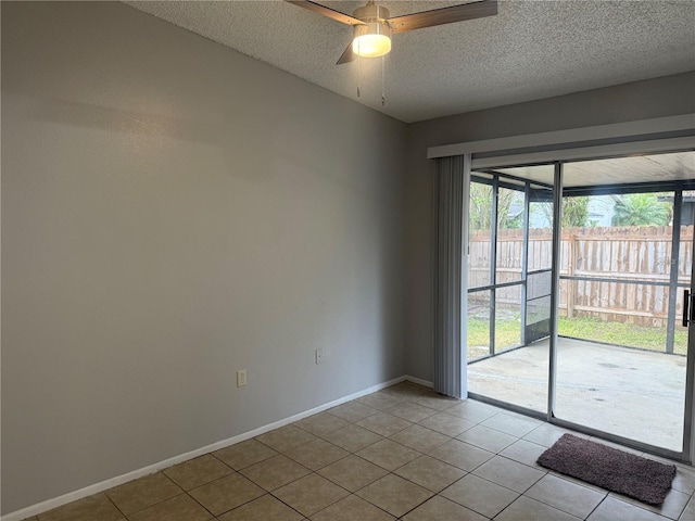 spare room featuring baseboards, a textured ceiling, a ceiling fan, and tile patterned flooring