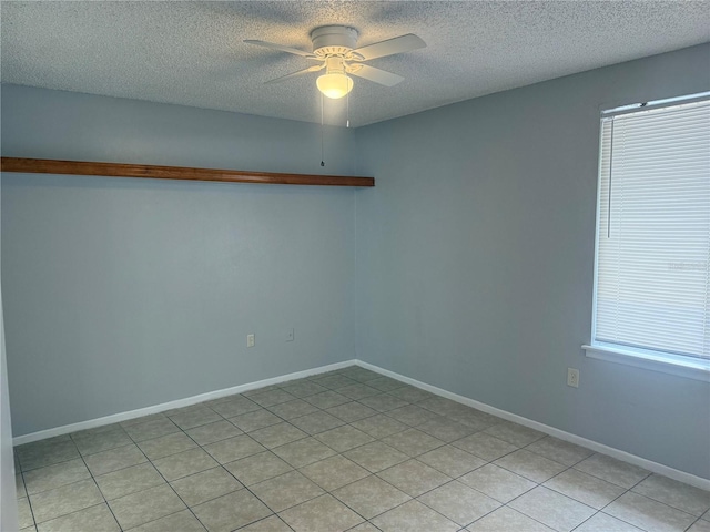 spare room with a textured ceiling, baseboards, and ceiling fan