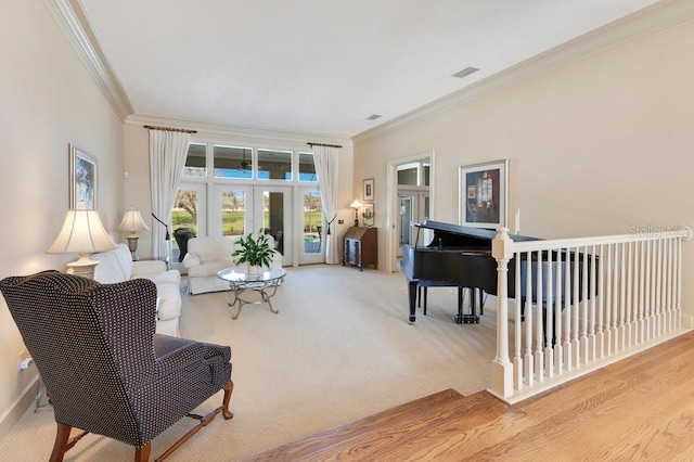 sitting room with light carpet, ornamental molding, and french doors