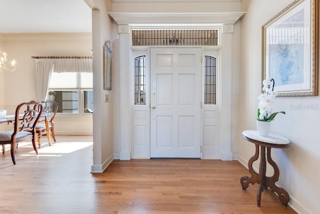 entryway with light hardwood / wood-style floors and an inviting chandelier